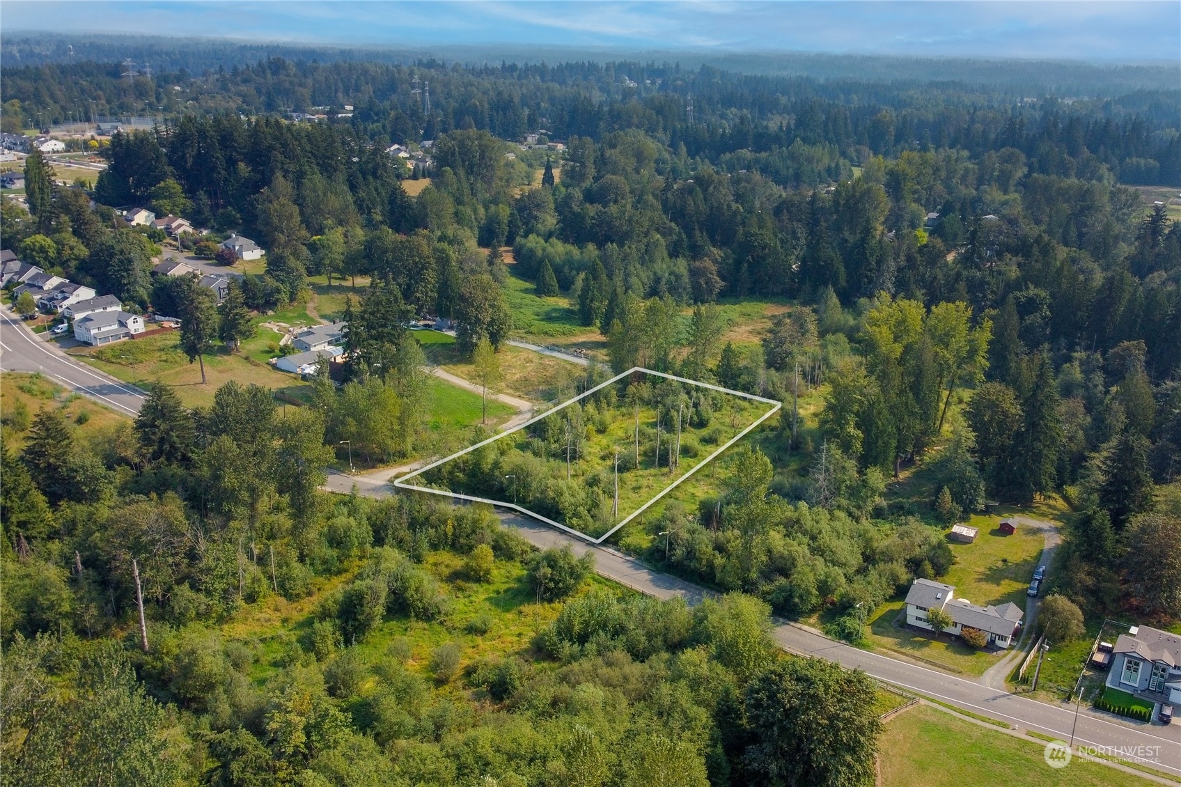 an aerial view of a residential houses with a yard and lake view