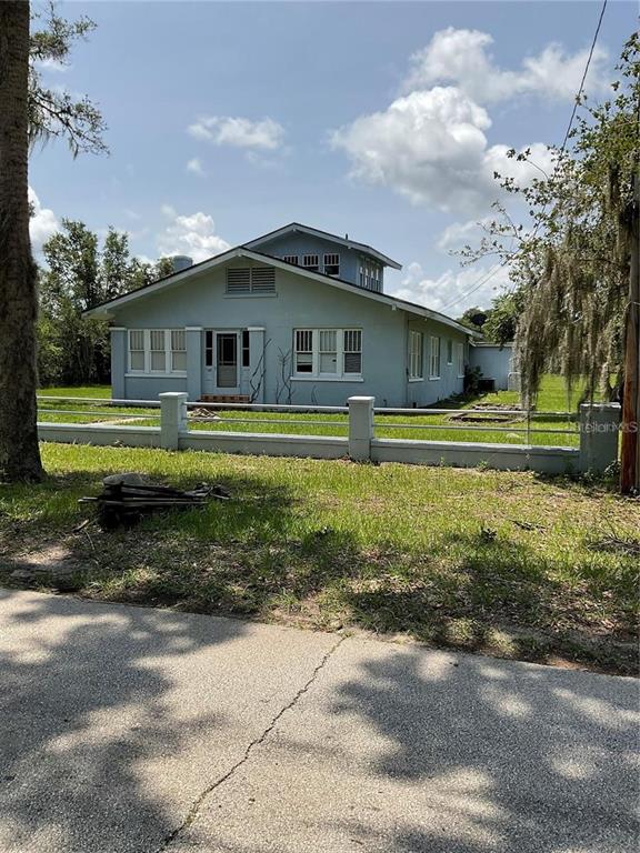 a front view of a house with a garden and trees