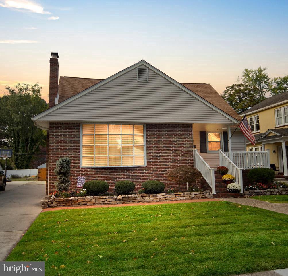 a front view of a house with a garden and trees