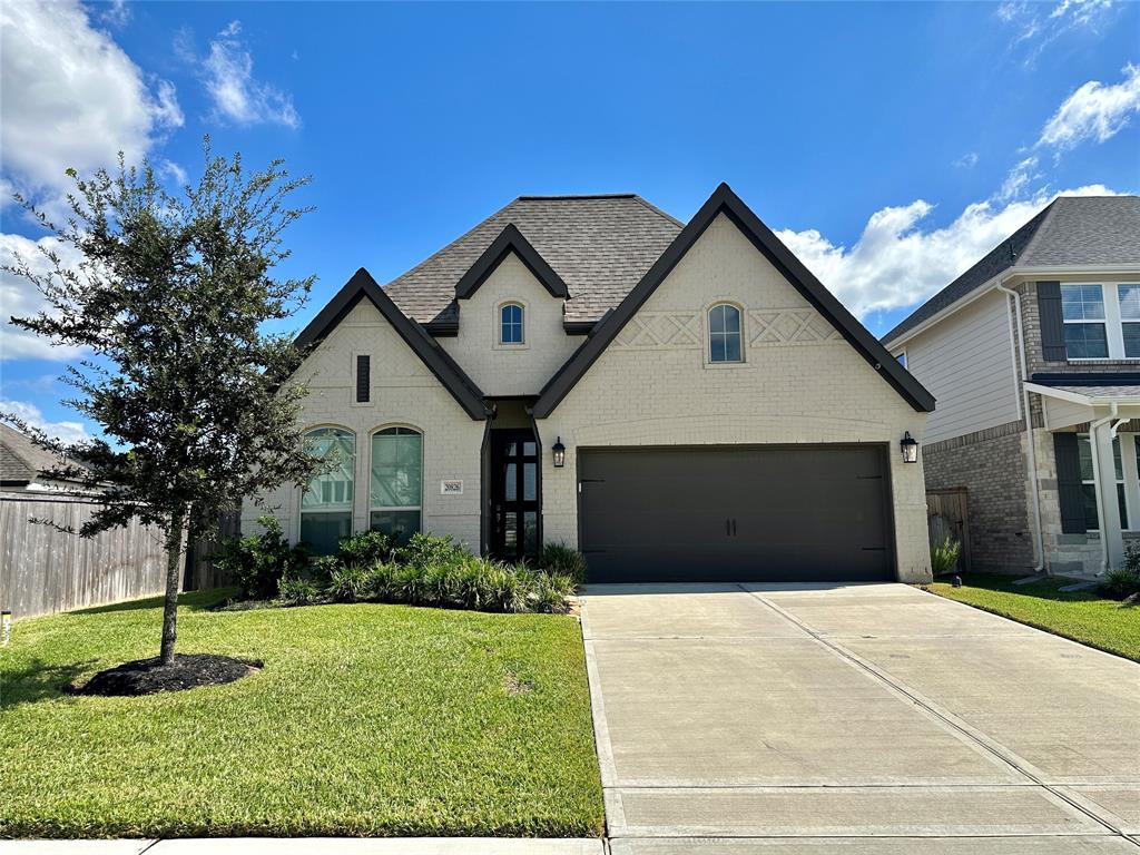 a front view of a house with a yard and garage