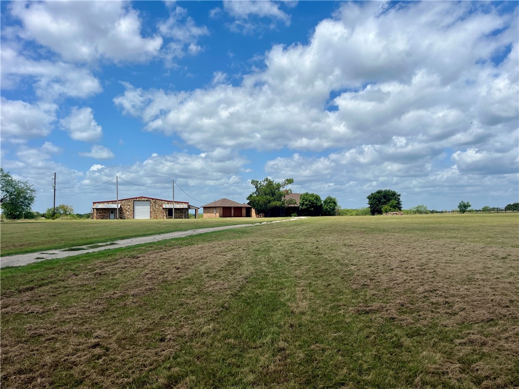 a view of a green field with house in the background