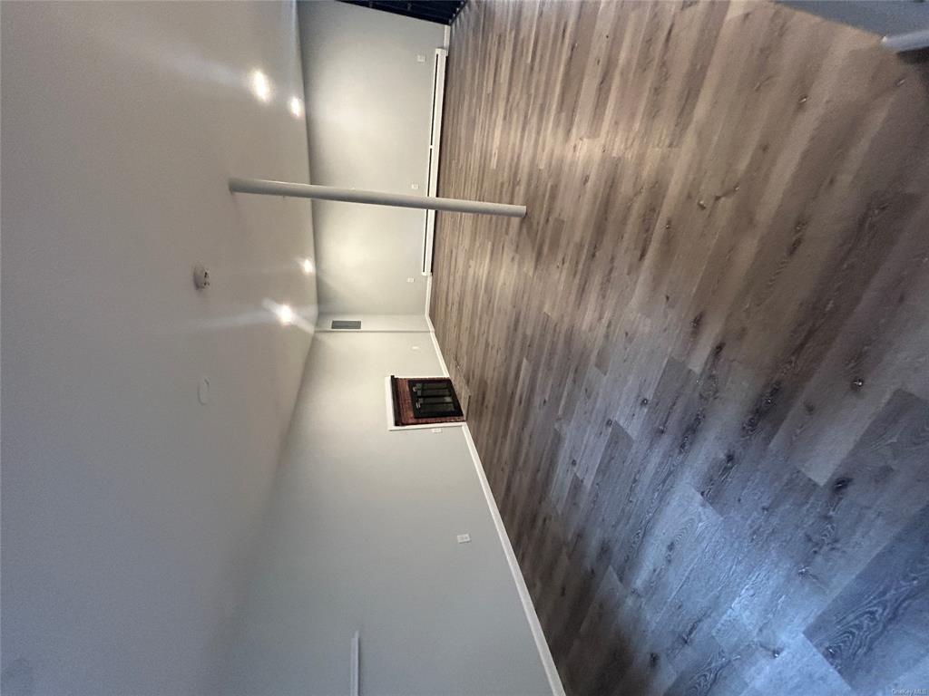 Basement featuring dark wood-type flooring and a baseboard heating unit