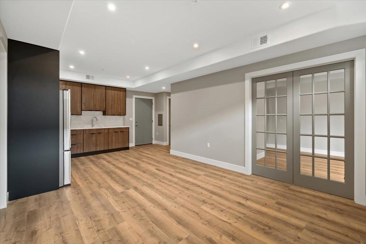 a view of empty room with wooden floor and window