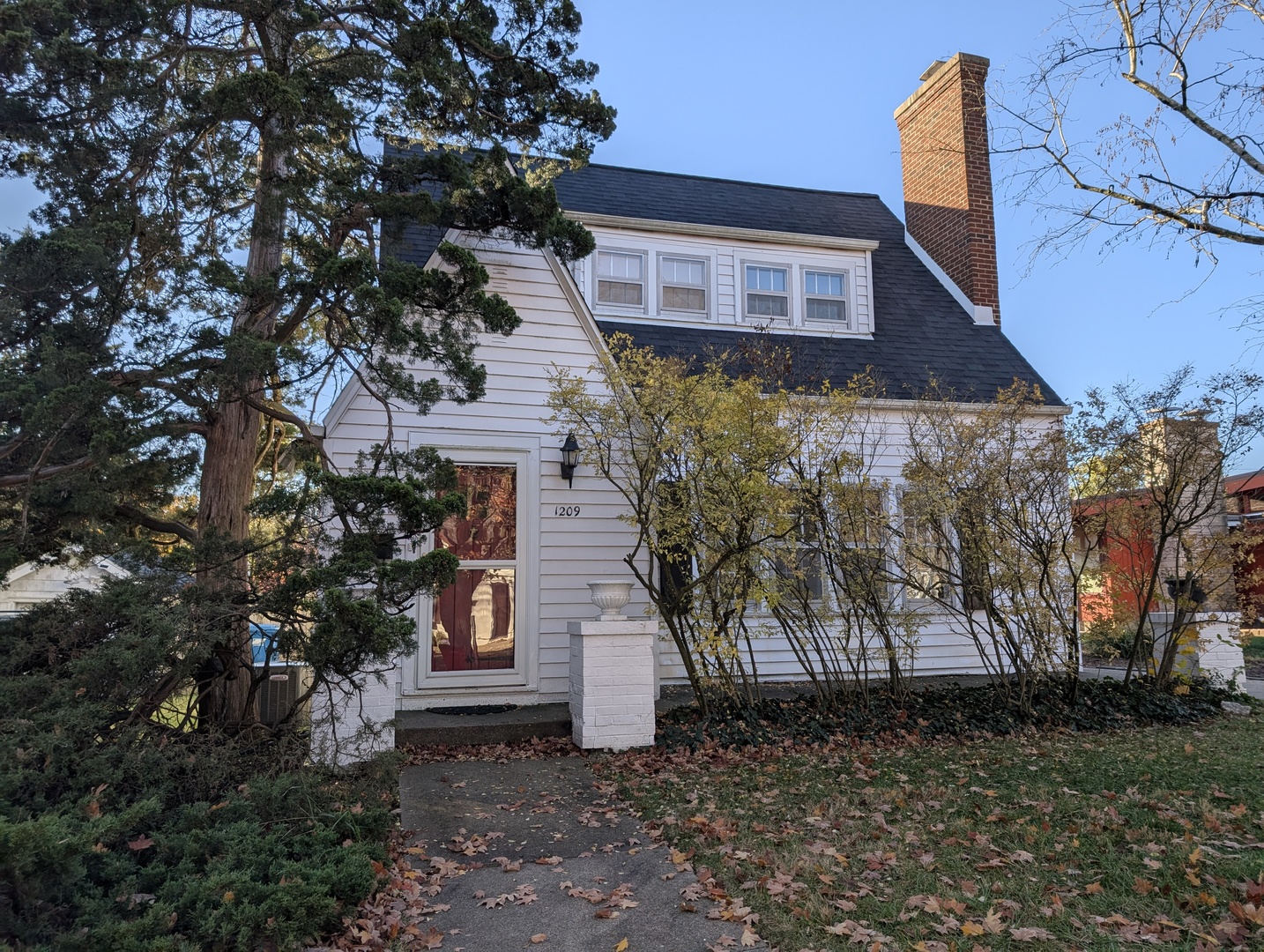 a brick house with tree in front of it