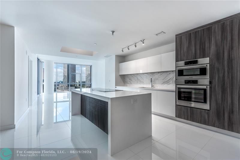 a large kitchen with kitchen island a sink stainless steel appliances and cabinets