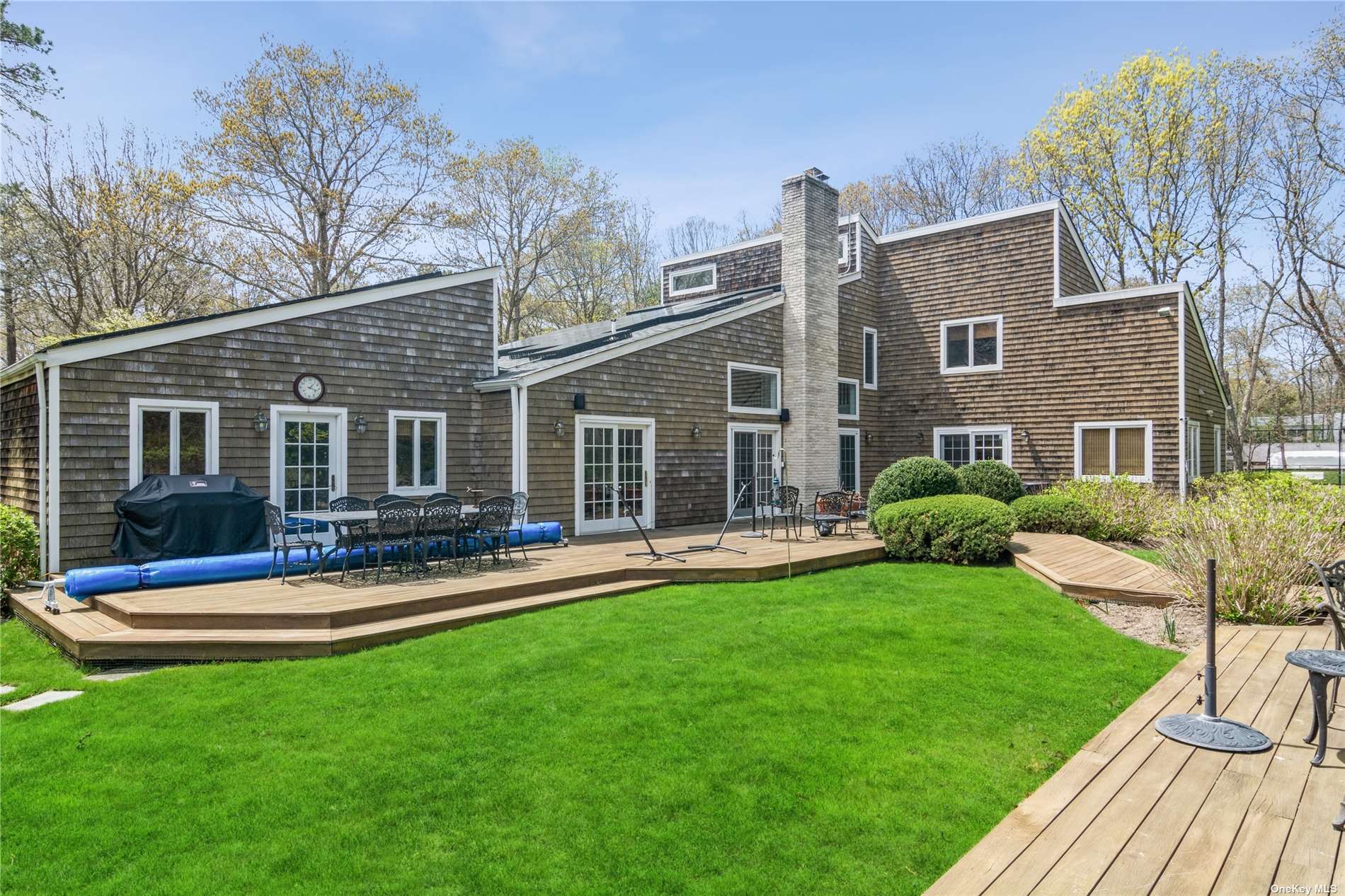 a front view of a house with swimming pool and garden