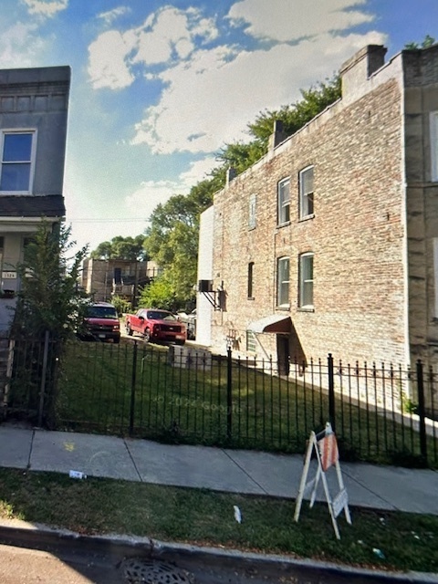 a view of a brick house next to a yard