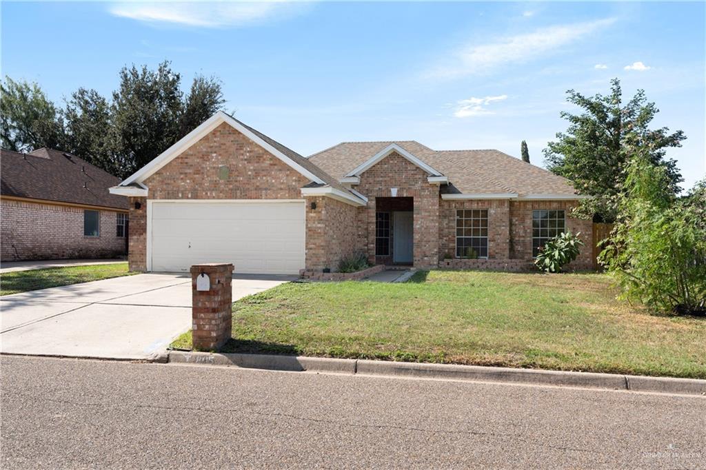 Ranch-style house with a garage and a front lawn