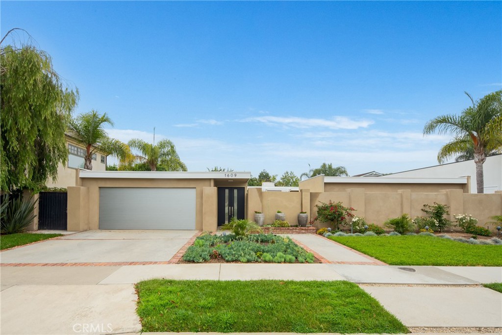 front view of a house with a yard and potted plants