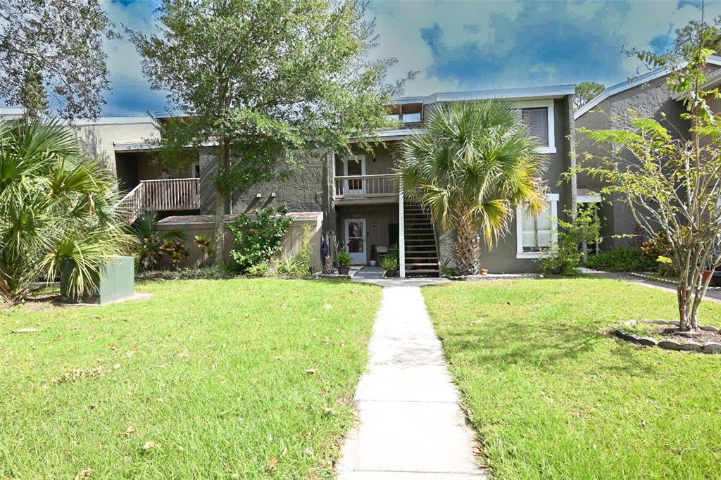 a front view of a house with a yard and potted plants