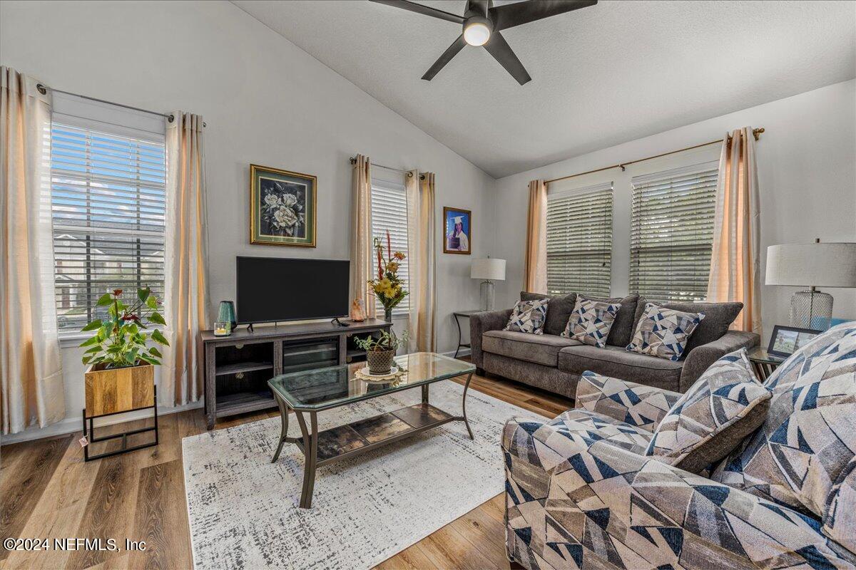 a living room with furniture a flat screen tv and a large window