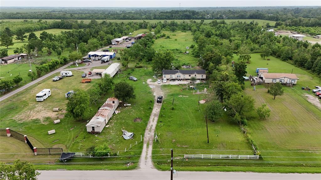 an aerial view of a residential houses with outdoor space and trees