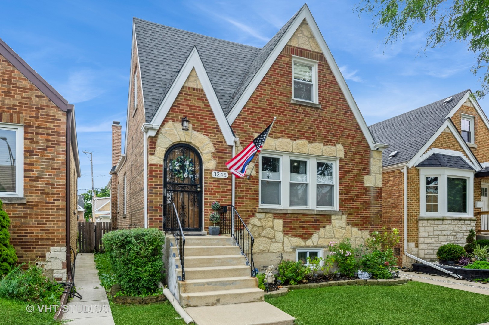 a view of a brick house with many windows and a yard