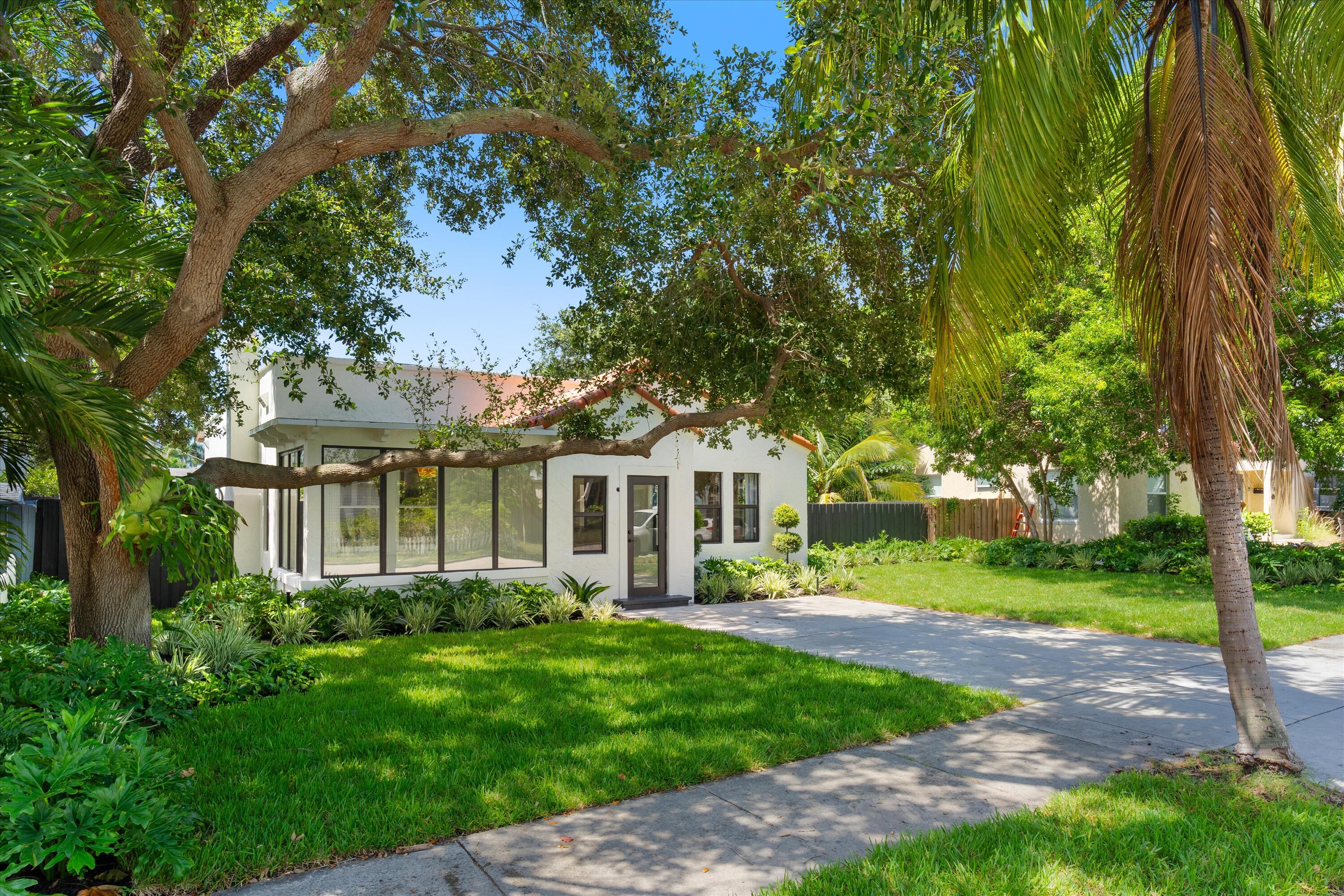 a front view of a house with a garden and trees