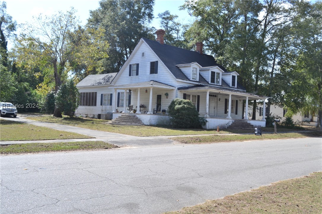 Farmhouse with a porch and a front lawn