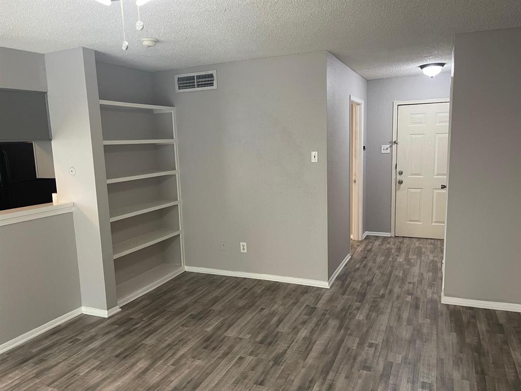 a view of empty room with wooden floor and closet