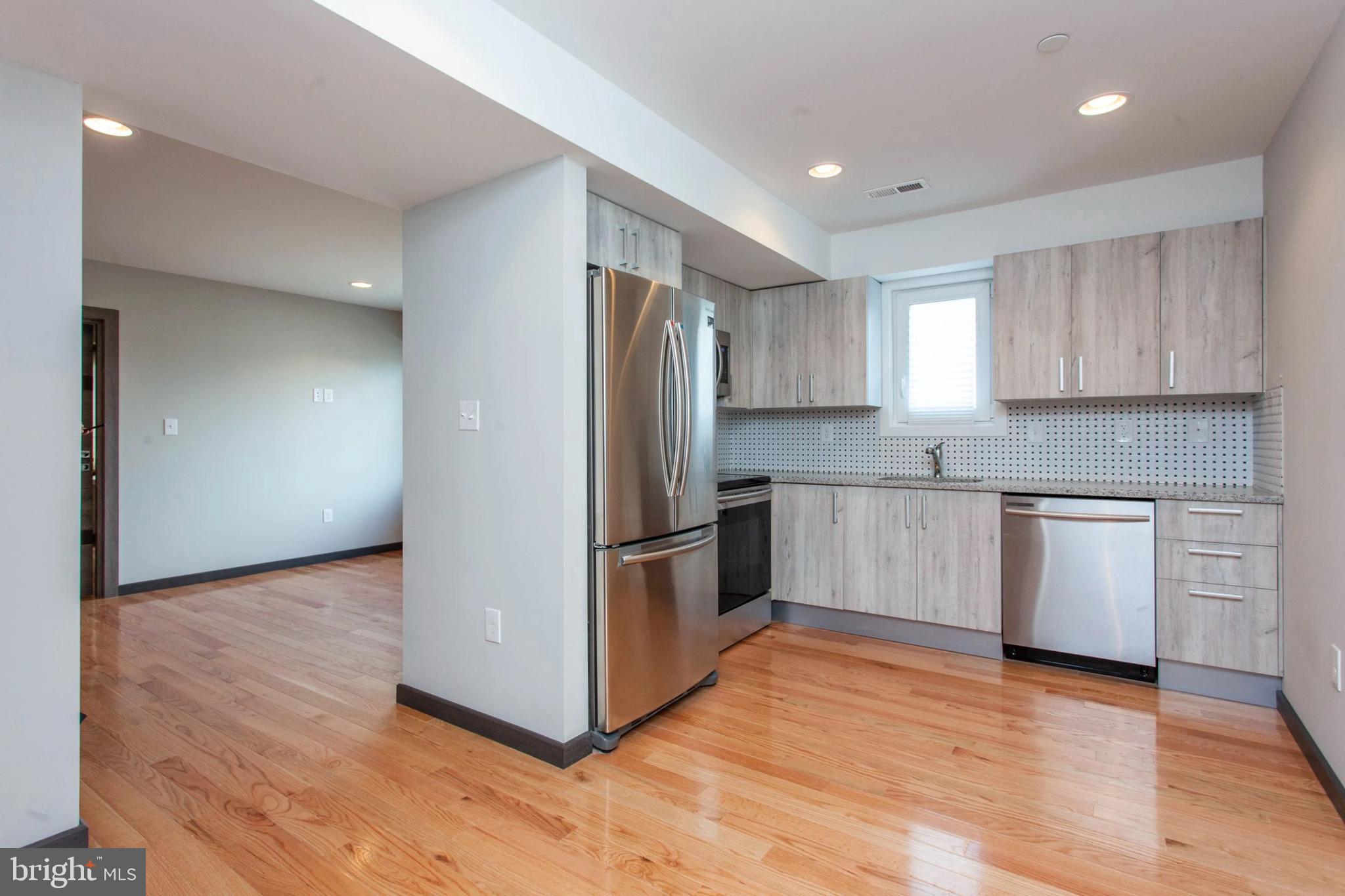 a kitchen with granite countertop a refrigerator and a stove top oven