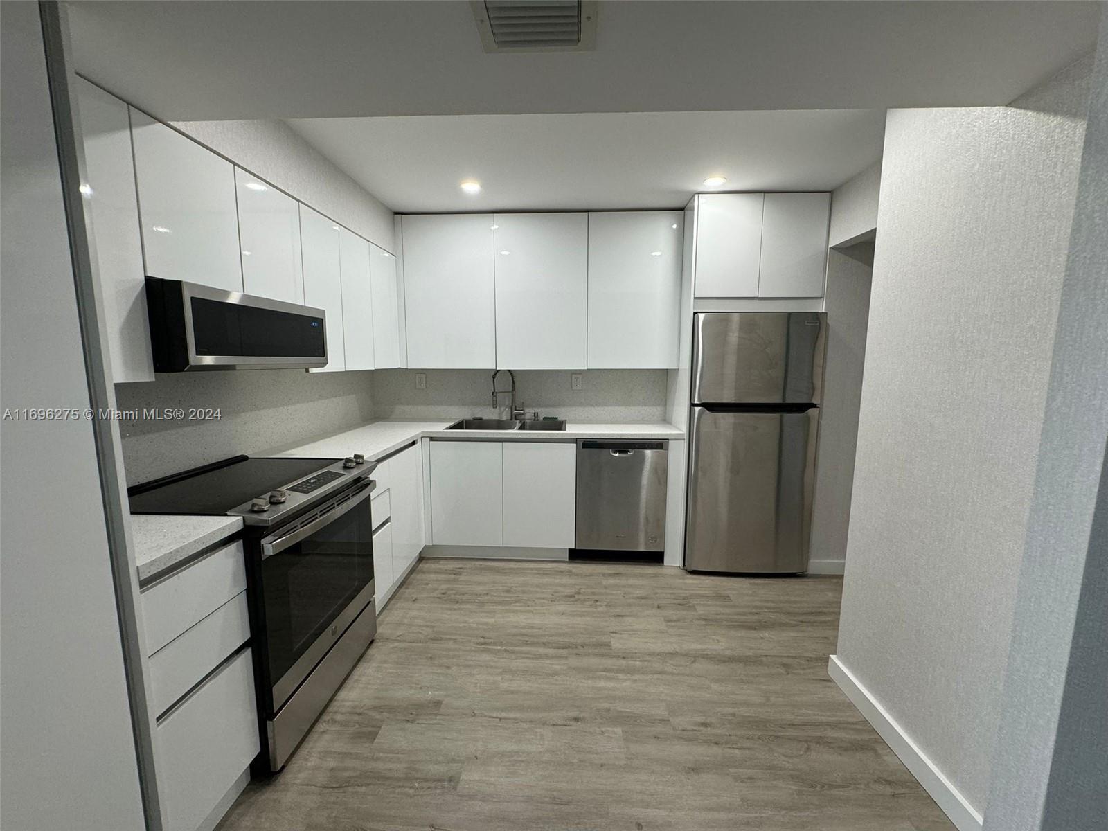 a kitchen with stainless steel appliances granite countertop a refrigerator and a stove top oven