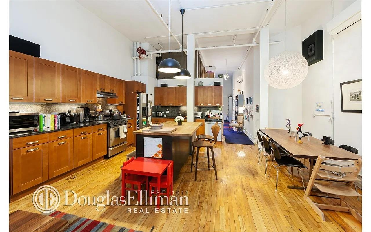 a kitchen with a table chairs stove and wooden floor