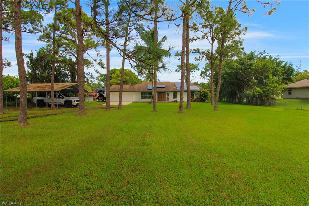 a view of a yard with a house and large trees