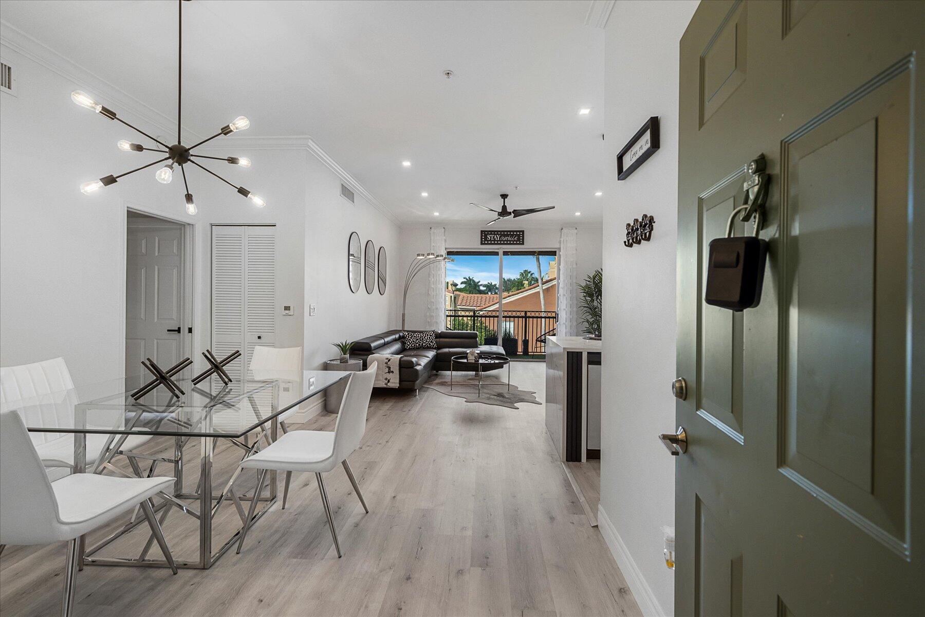 a view of a dining room and livingroom with furniture wooden floor a chandelier