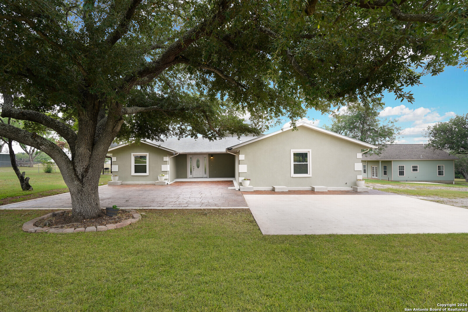 a front view of house with yard and trees