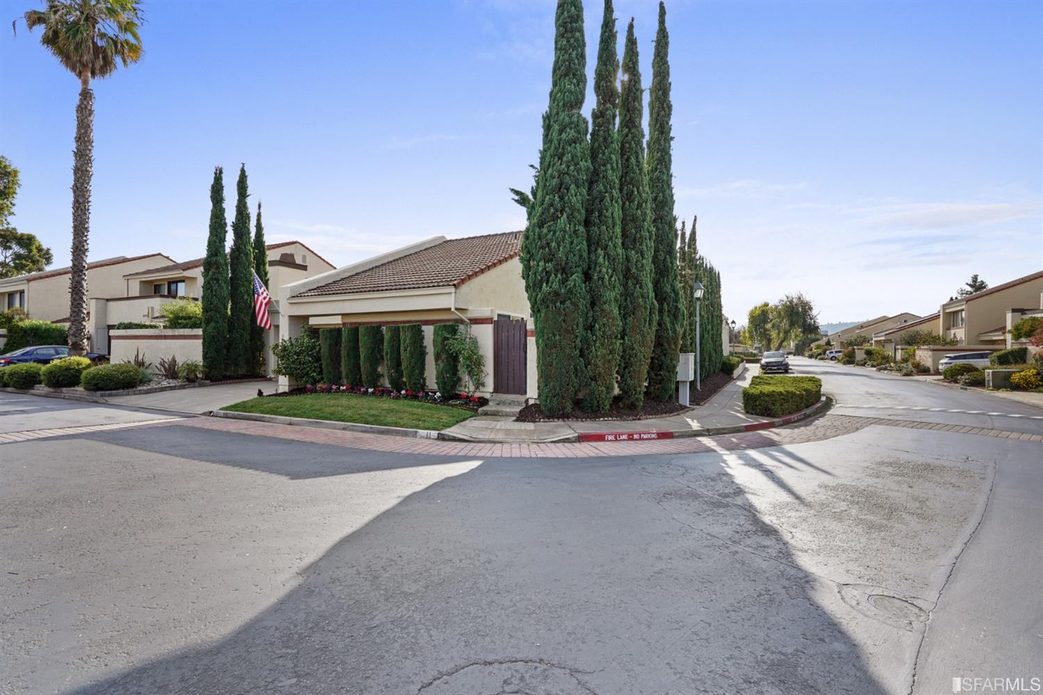 a front view of a house with a yard and potted plants