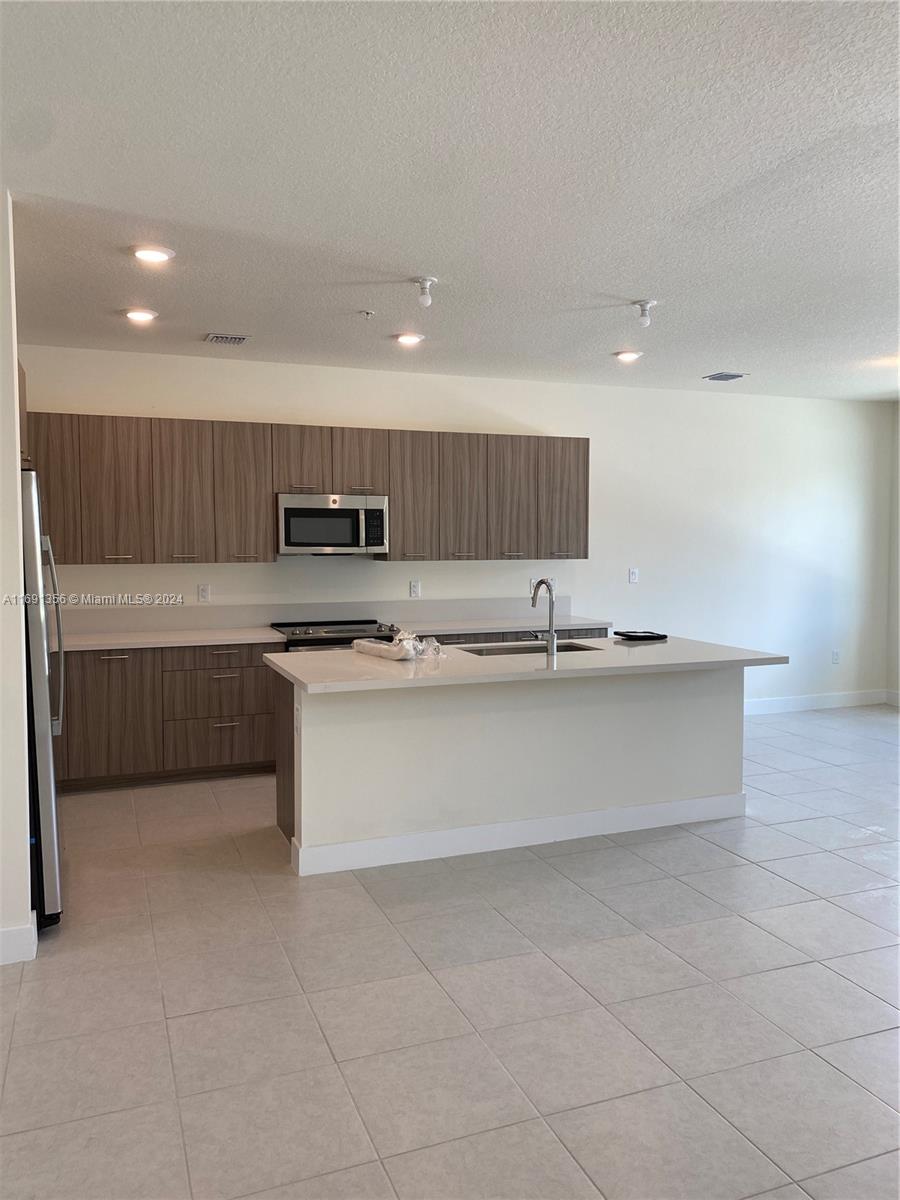 a kitchen with stainless steel appliances granite countertop a stove a sink and a refrigerator