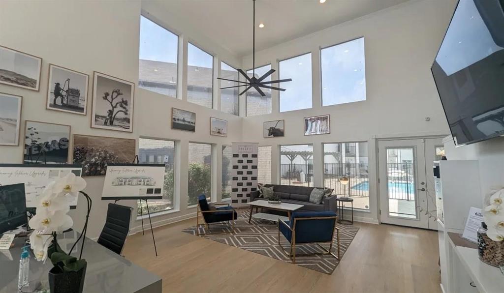 a living room with furniture a flat screen tv and floor to ceiling window