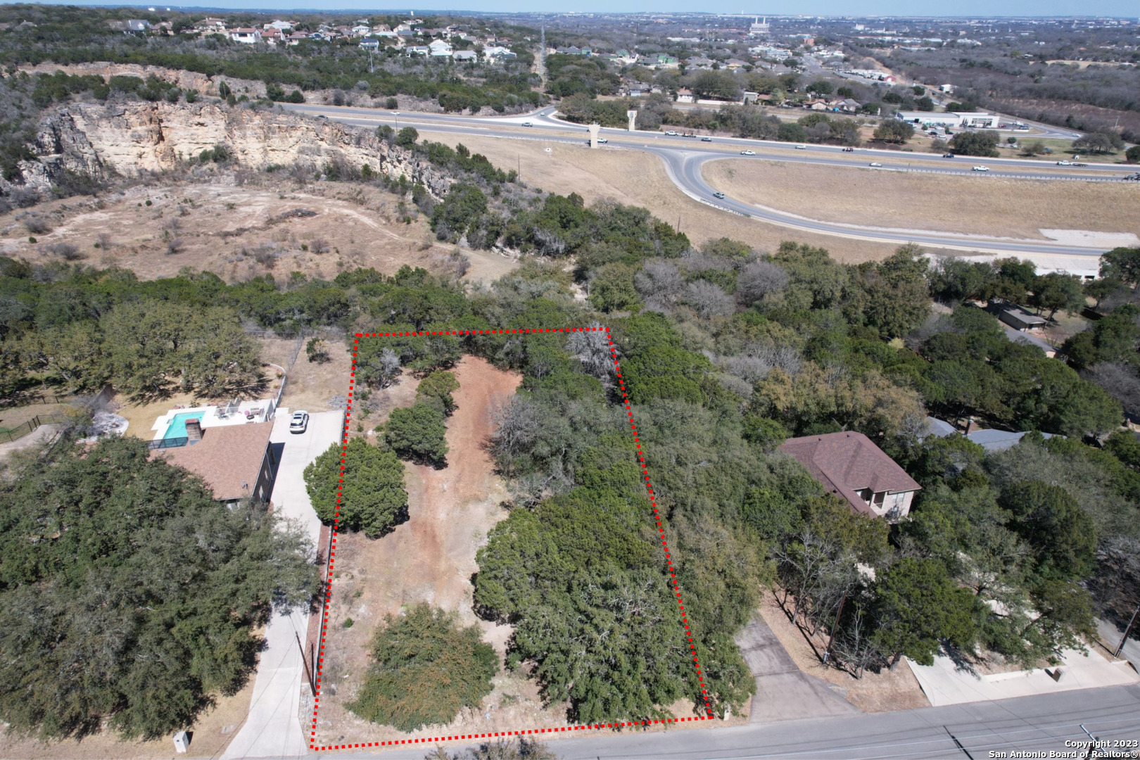 an aerial view of residential houses with outdoor space and trees