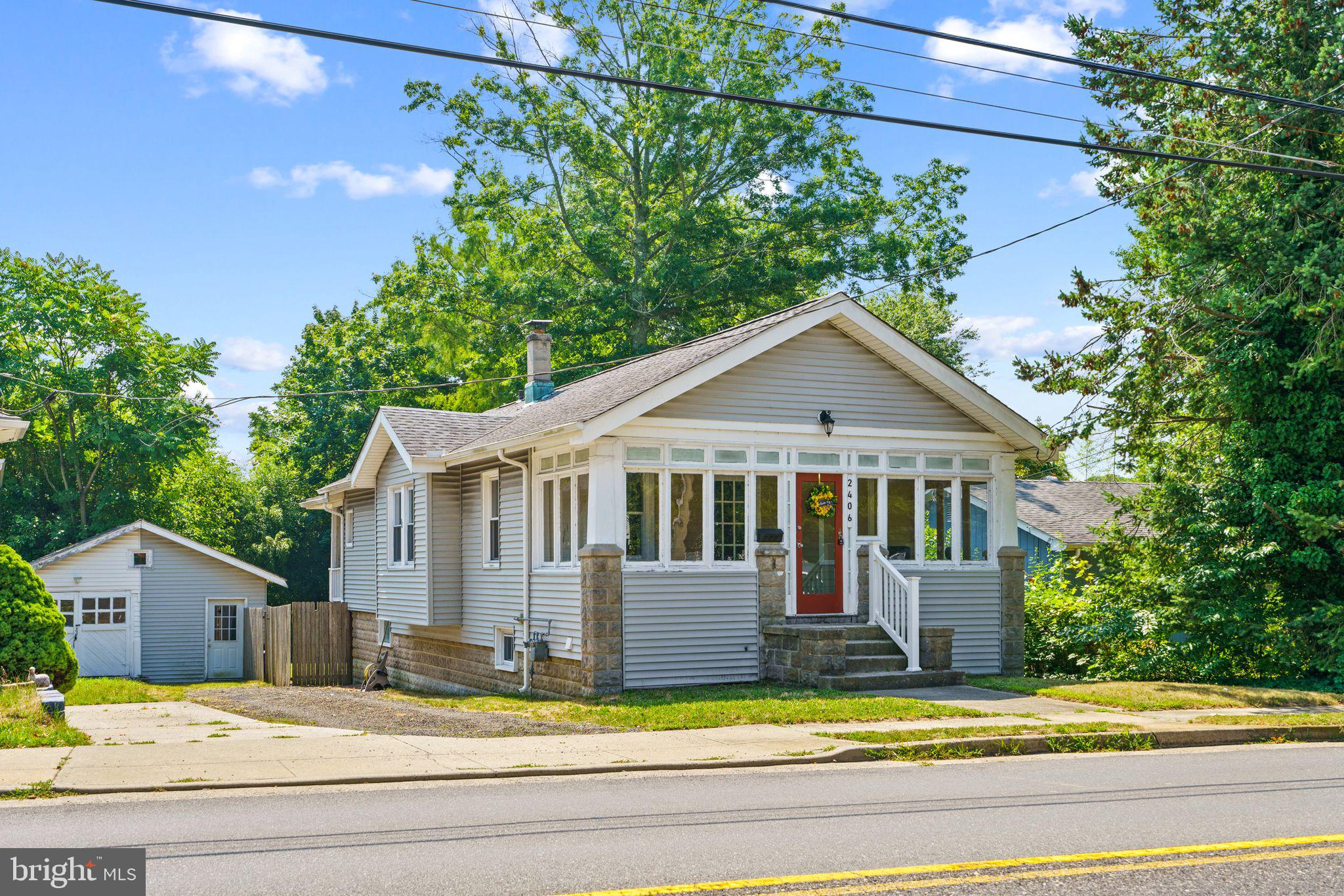 a view of a house with a small yard plants and large tree