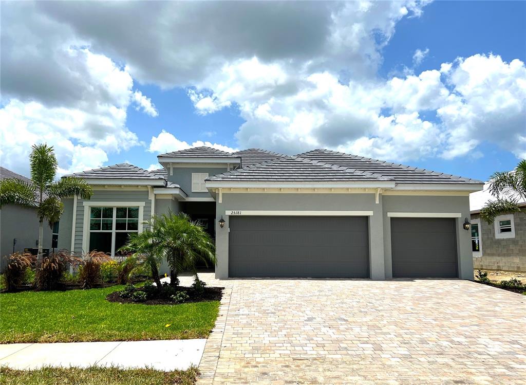 a front view of a house with a garden and yard