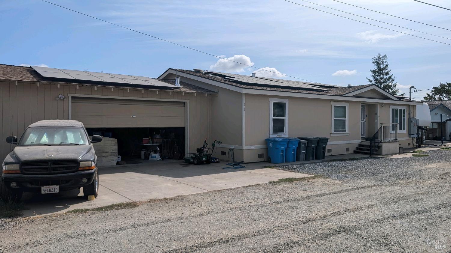 a view of a house with a yard and a car parked in garage