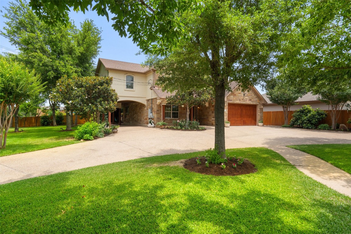 a front view of a house with a yard and tree