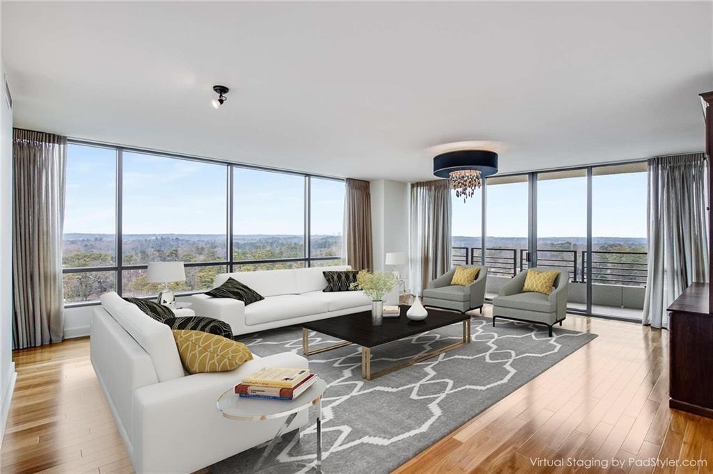 a living room with furniture and floor to ceiling windows