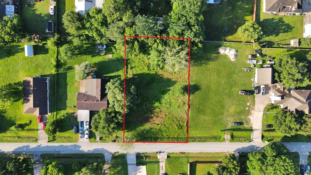 an aerial view of a house with a yard and large trees