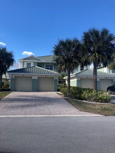 a view of a house with a yard and palm trees