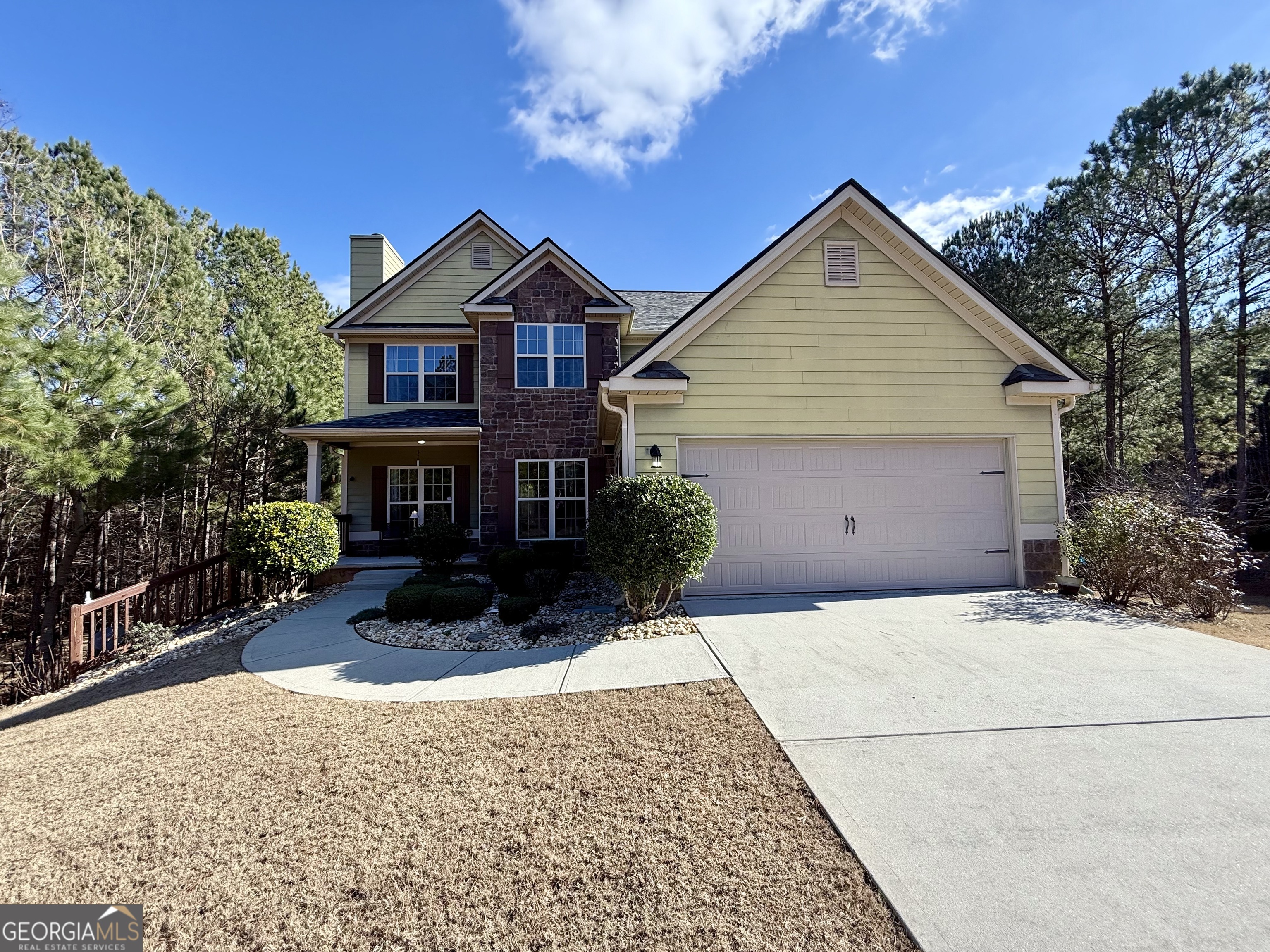 a front view of house with yard and trees in the background