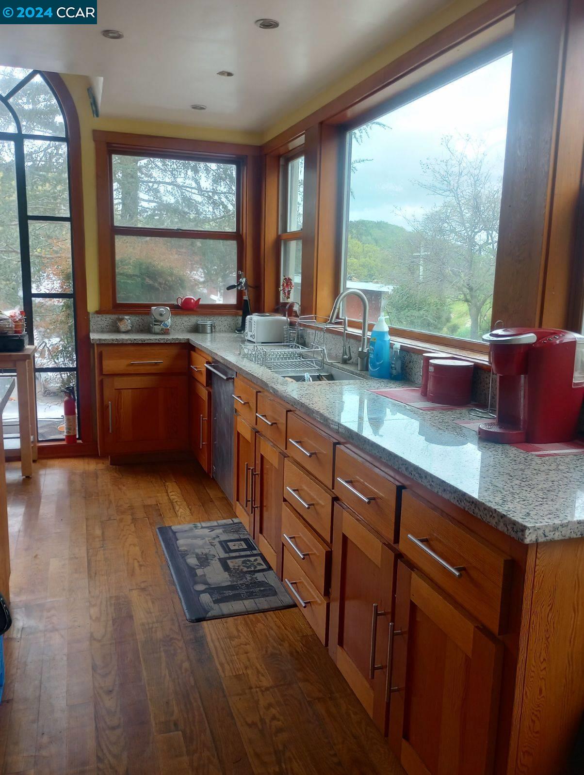 a kitchen with stainless steel appliances granite countertop a stove a sink and a wooden cabinets