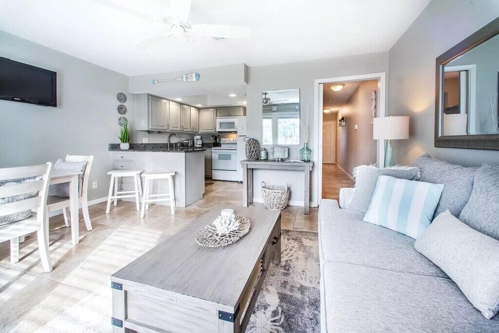 a living room with furniture kitchen view and a flat screen tv