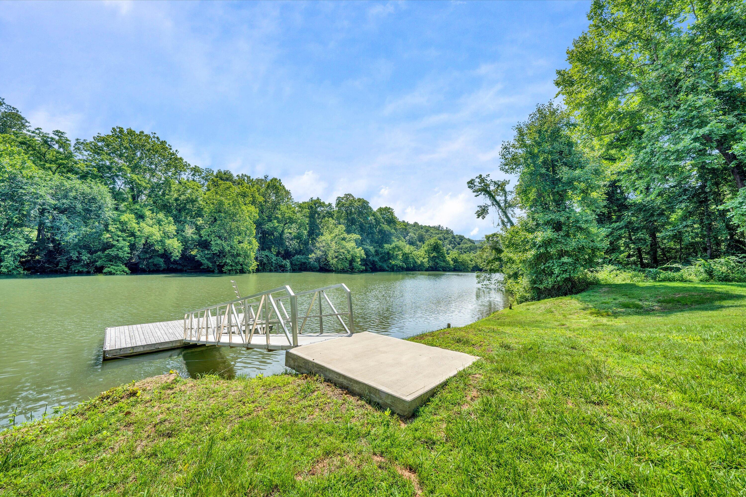 a view of a lake with a bench and trees