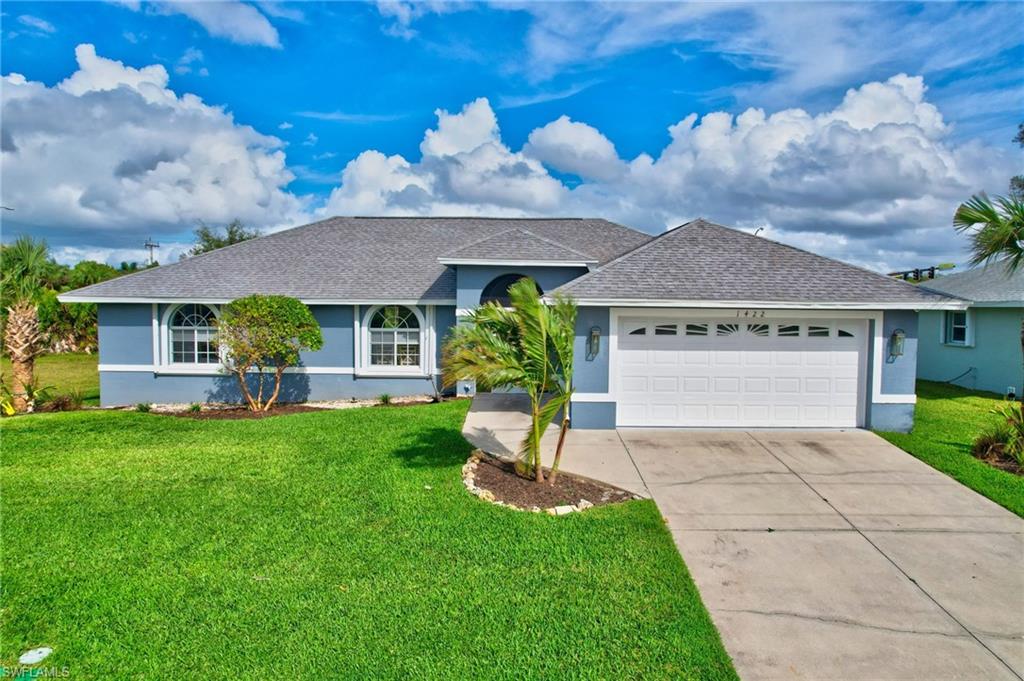 a front view of a house with a garden and yard