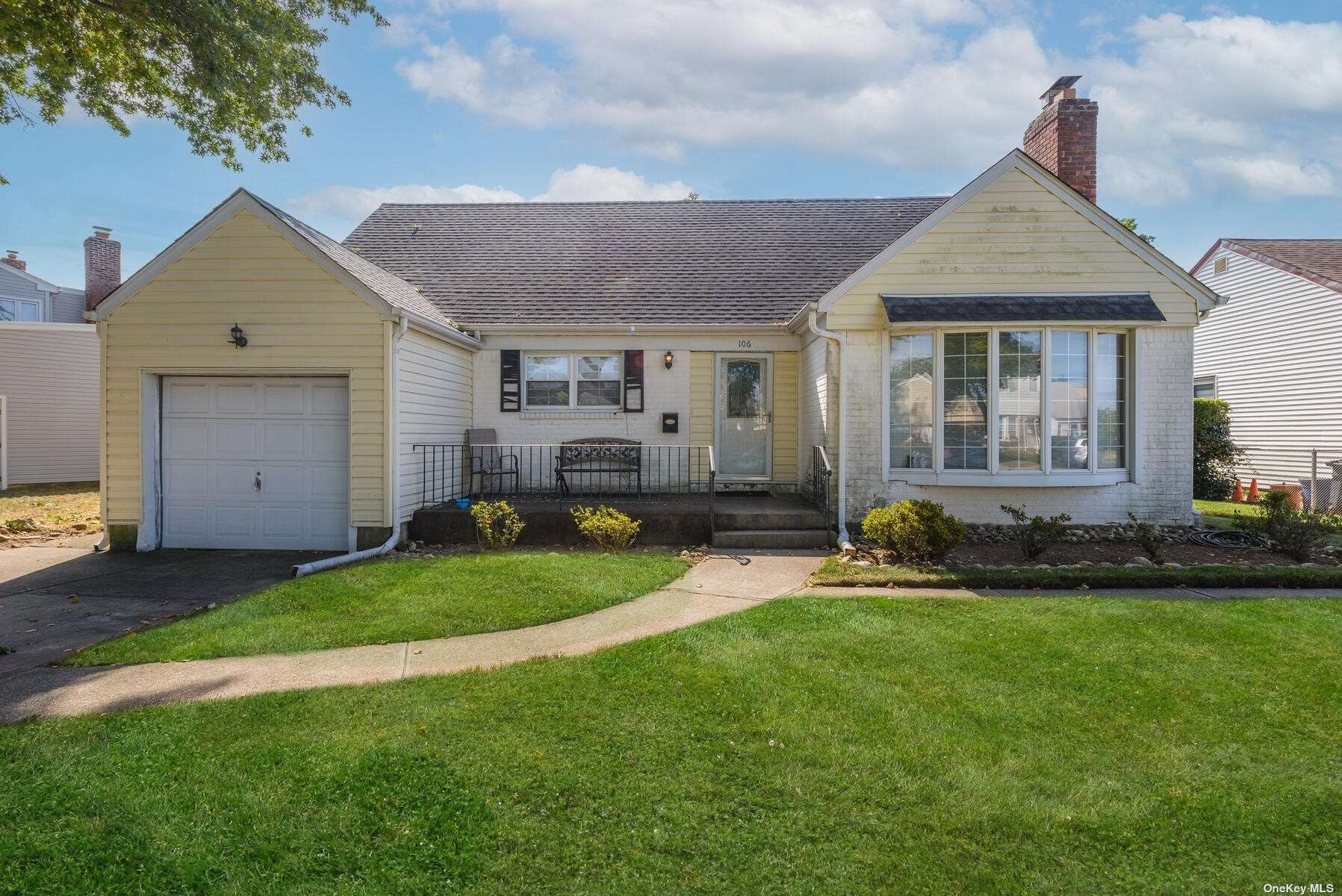 a front view of a house with a garden and yard