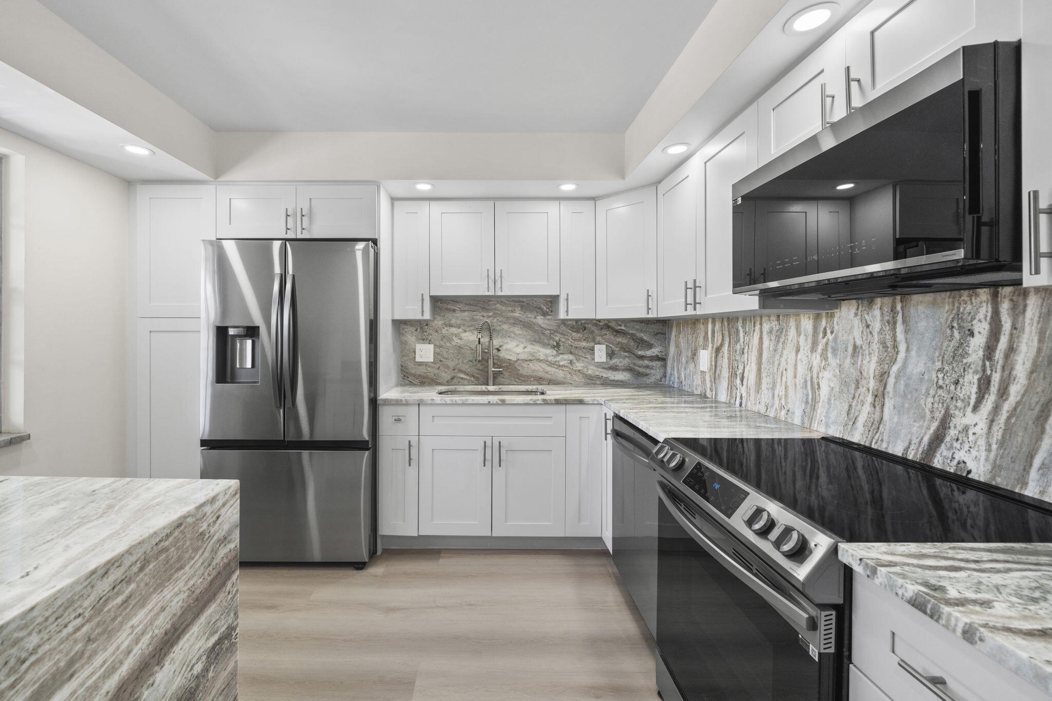 a kitchen with a sink a refrigerator and a stove top oven