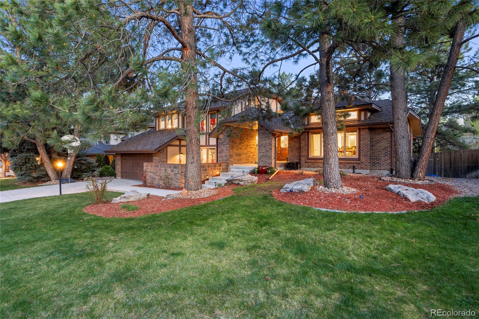 a front view of a house with a yard and trees