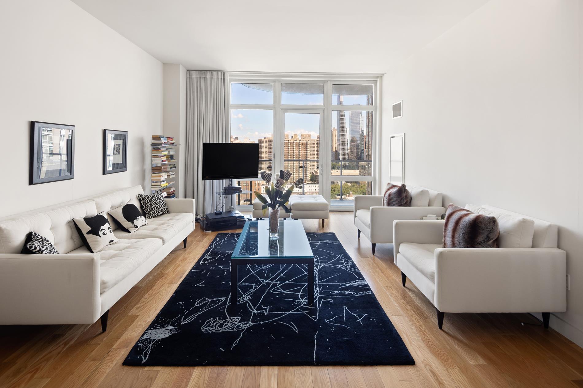 a living room with furniture wooden floor and a large window