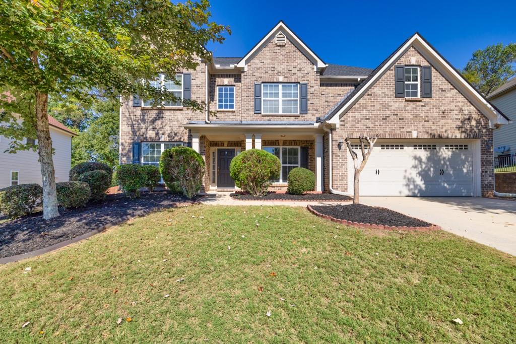 a front view of a house with a yard and garage