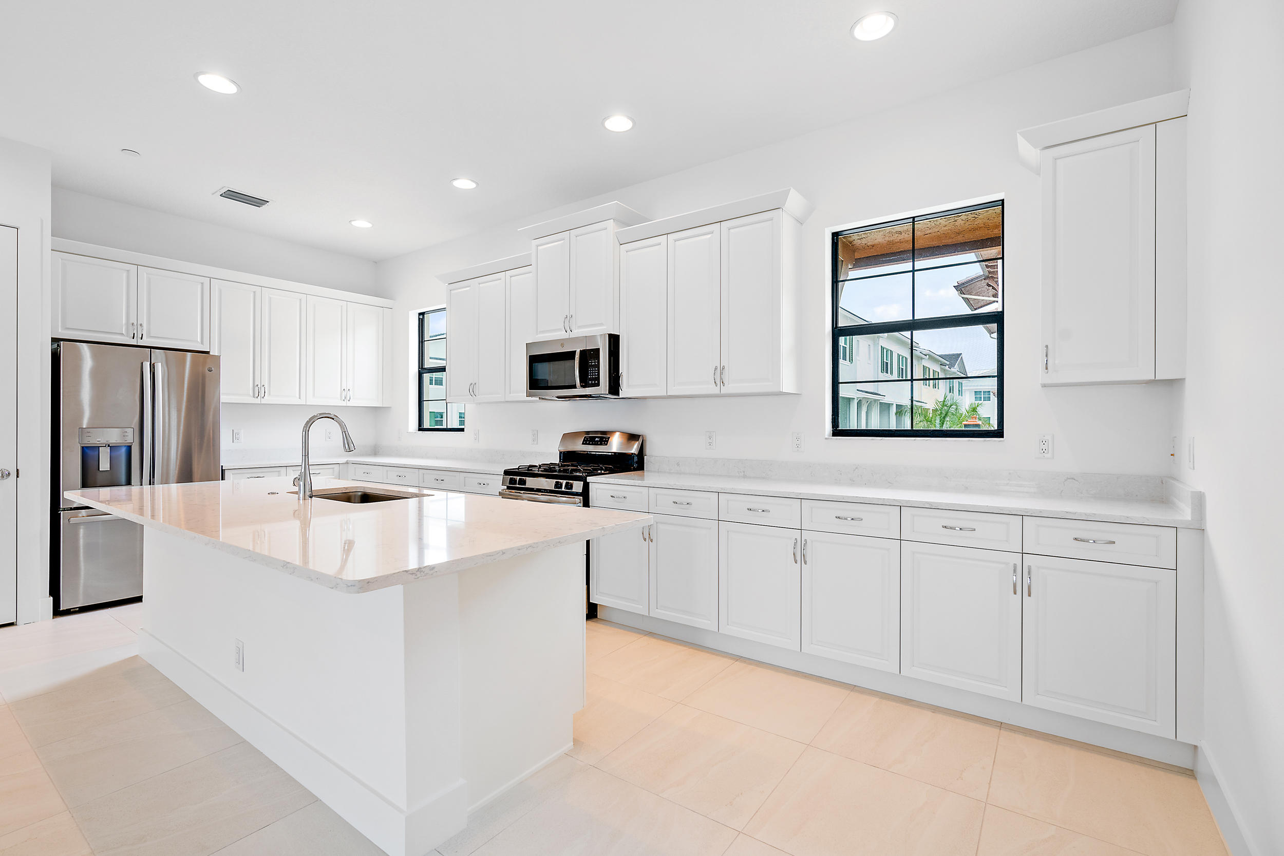 a large white kitchen with stainless steel appliances