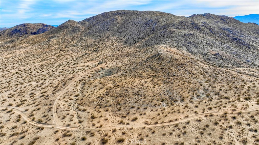 a view of a dry yard with mountains in the background