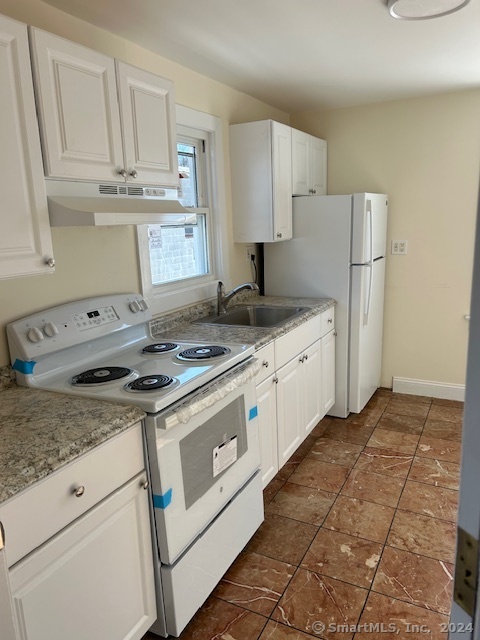 a kitchen with granite countertop a sink stove and refrigerator